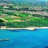Vista aerea di una città costiera e vegetazione.