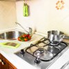 Cucina con fornello, lavello e utensili.