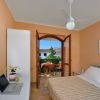 Una camera da letto con balcone, letto matrimoniale e ventilatore a soffitto.