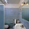 Un bagno moderno con piastrelle blu, doccia e lavandino.