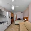 Camera con cucina, letto e divano beige.