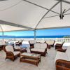 Un patio coperto con mobili in vimini e vista mare.