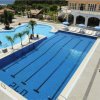 Piscina grande con ombrelloni blu e lettini.
