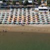 Spiaggia con ombrelloni disposti ordinatamente.
