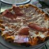 Pizza con fette di prosciutto e formaggio.