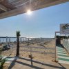 Accesso a spiaggia sabbiosa con sedie a sdraio.