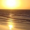 Tramonto su una spiaggia con mare calmo.