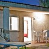 Bungalow con veranda illuminata, tavolo e sedie.