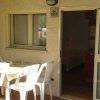 Terrazza con tavolo coperto e sedie di plastica bianche.