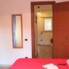 Camera con letto rosso, TV e armadio blu.
