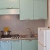 Cucina con mobili azzurri e frigorifero bianco.