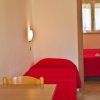 Letto con copriletto rosso in una stanza luminosa.