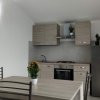 Cucina moderna con tavolo, sedie e piante decorative.