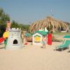 Area giochi in spiaggia con sdraio e scivolo.
