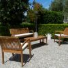 Arredo da giardino in legno su fondo ghiaioso.