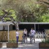 Persone con biciclette vicino a un edificio di legno.