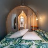 Interno di una tenda con letto e coperte tropicali.