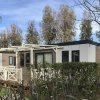 Casetta prefabbricata con veranda immersa nel verde.