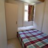 Camera con letto matrimoniale e copriletto a quadri.