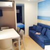 Soggiorno con divano blu, tavolo e aria condizionata.