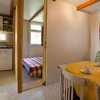 Cucina e zona pranzo con tavolo giallo.