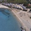 Spiaggia e mare limpido con camper vicini.