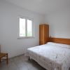 Camera con letto matrimoniale e armadio, finestra luminosa.