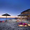 Spiaggia con ombrelloni al tramonto.