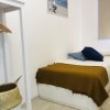 Camera moderna con letto singolo, cuscini colorati.