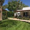 Bungalow moderno con giardino verde e alberi.