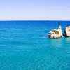 Mare azzurro con due grandi scogli al centro.