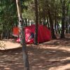 Una tenda rossa nel bosco tra gli alberi.