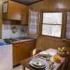 Cucina accogliente con tavola apparecchiata e finestra vista giardino.
