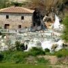 Cascate con piscine termali a terrazze e persone che nuotano.
