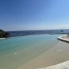 Piscina a sfioro con vista sul mare e cielo blu.