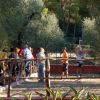 Un gruppo di persone gioca all'aperto in un'area circondata da alberi.