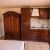 Interni con armadio, cucina in legno e letto.