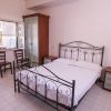 Una camera con letto matrimoniale in ferro e arredi semplici.