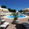 Piscina circondata da lettini e ombrelloni bianchi.