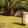 Giardino con sdraio, tenda e giochi.