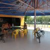 Persone intorno a un tavolo con bici nei pressi di un campo da tennis.