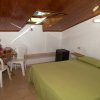 Camera mansardata con letto verde e tavolo.