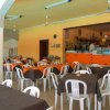 Sala da pranzo con tavoli e sedie bianche.