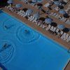 Piscina con ombrelloni a righe bianche e blu.