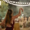 Persona che balla sotto le luci in una festa serale.