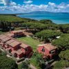 Complesso di edifici rossi circondati da alberi, vicino al mare.