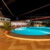 Piscina illuminata di notte con giochi di luce colorati.