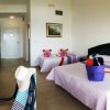 Camera d'hotel con tre letti e arredi moderni.
