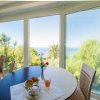 Tavolo con colazione e vista sul giardino e mare.