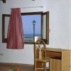 Una stanza con finestra vista mare, tavolo e sedia.